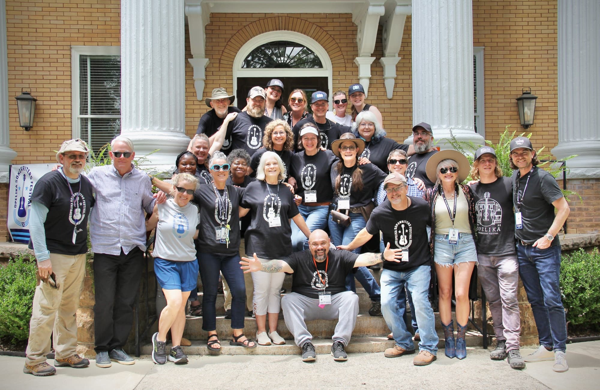 The OSF7 staff and volunteer team on the steps of a historic downtown Opelika building