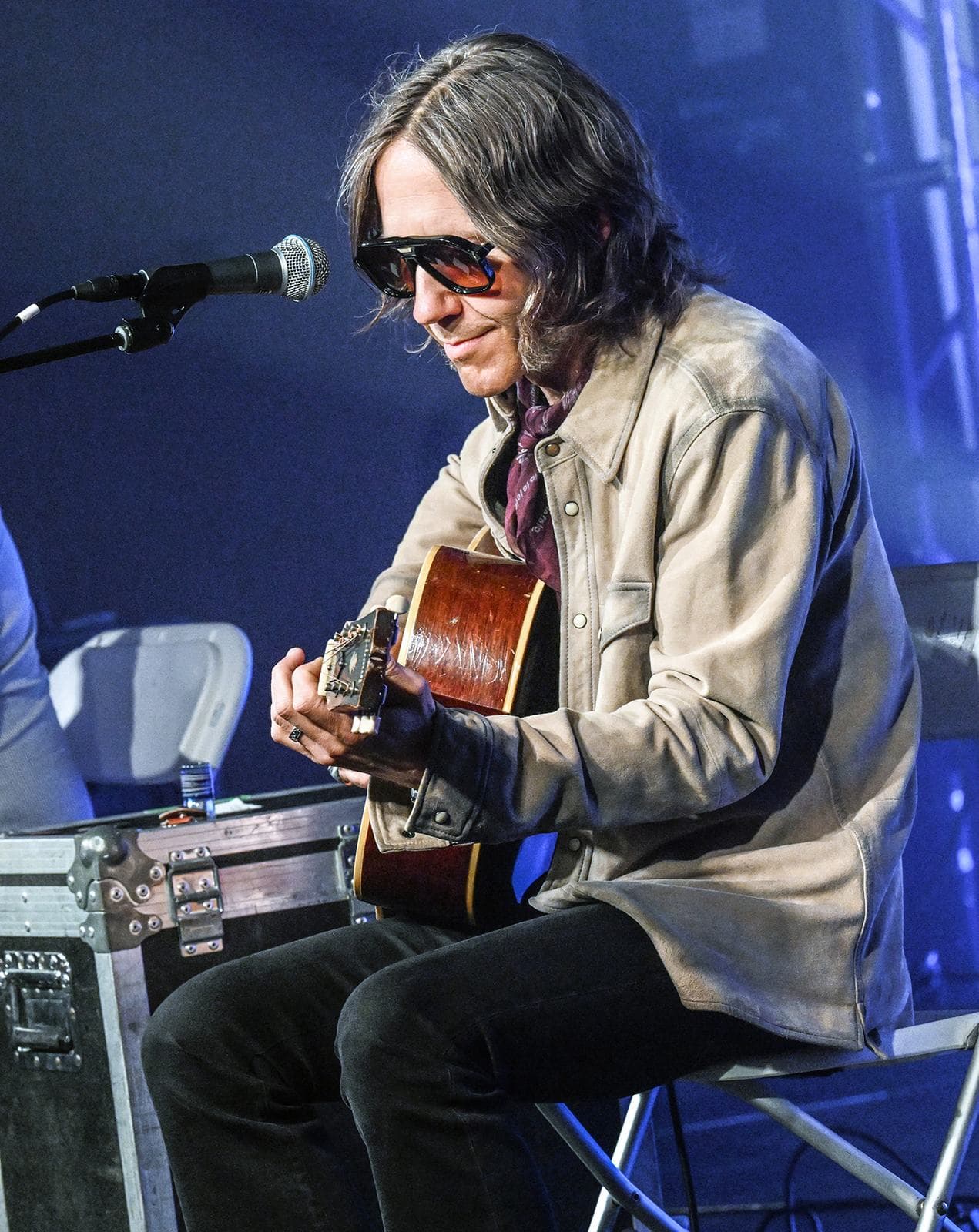 Charlie Starr of Blackberry Smoke playing acoustic under blue stage light