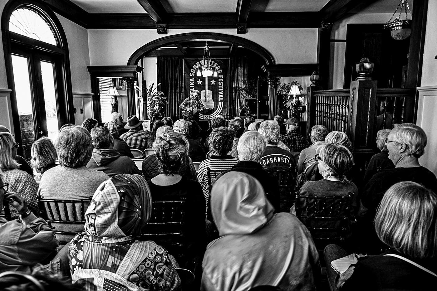 A full Heritage House parlour listening to a set, in black and white