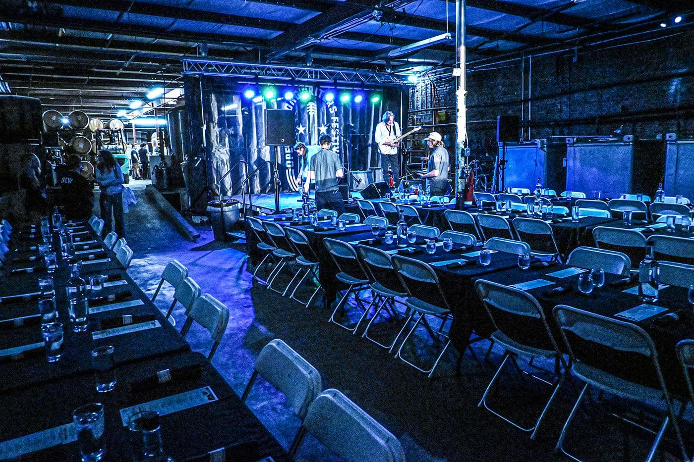 The John Emerald Distilling Company hall set with long tables before a night of music
