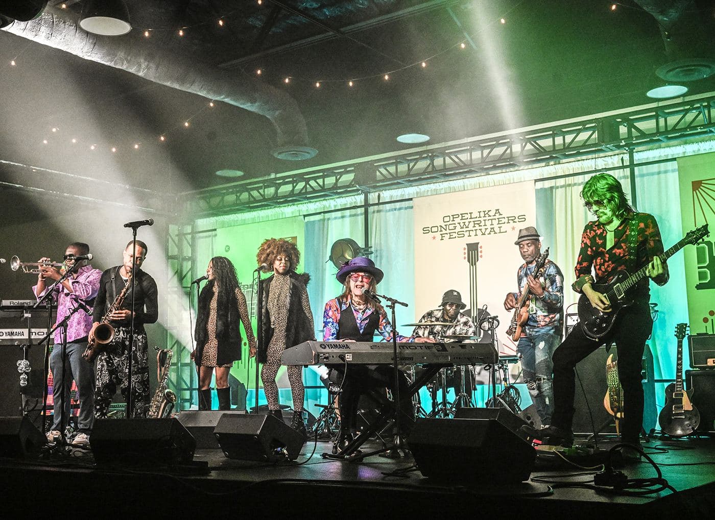 A full band and horn section on the festival stage during the late night jam