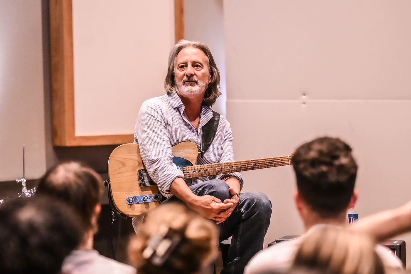 Guitarist Allen Hinds talking with music students gathered around him